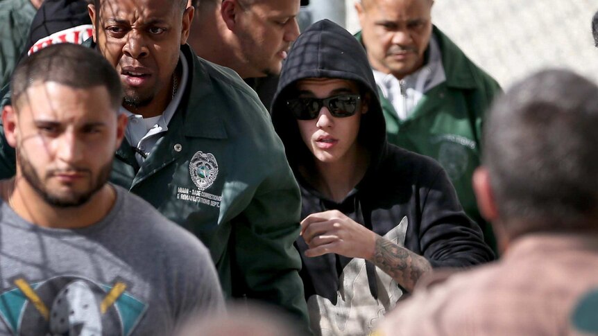 Justin Bieber walks to a car after being released from a Miami jail.