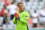 The German goalkeeper claps his hands on the pitch while wearing a rainbow armband supporting diversity and LGBTQ people.