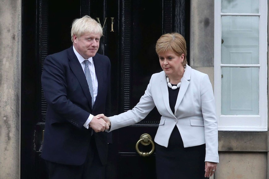 苏格兰首相尼古拉·斯特金（Nicola Sturgeon）与鲍里斯·约翰逊（Boris Johnson）握手，位于苏格兰爱丁堡一所房屋外。