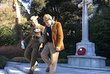 Jack Hopgood (right) is escorted down the steps from the Commonwealth War Cemetery