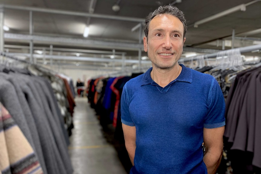 A man surrounded by clothes at Cue's Sydney warehouse.