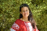 Profile of woman smiling, wearing red and white Ukrainian traditional top