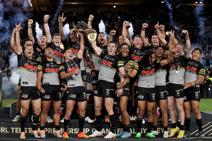 The Penrith Panthers celebrate with the NRL premiership trophy.