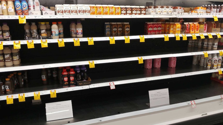 Milk shelves at a supermarket with empty rows of iced coffee