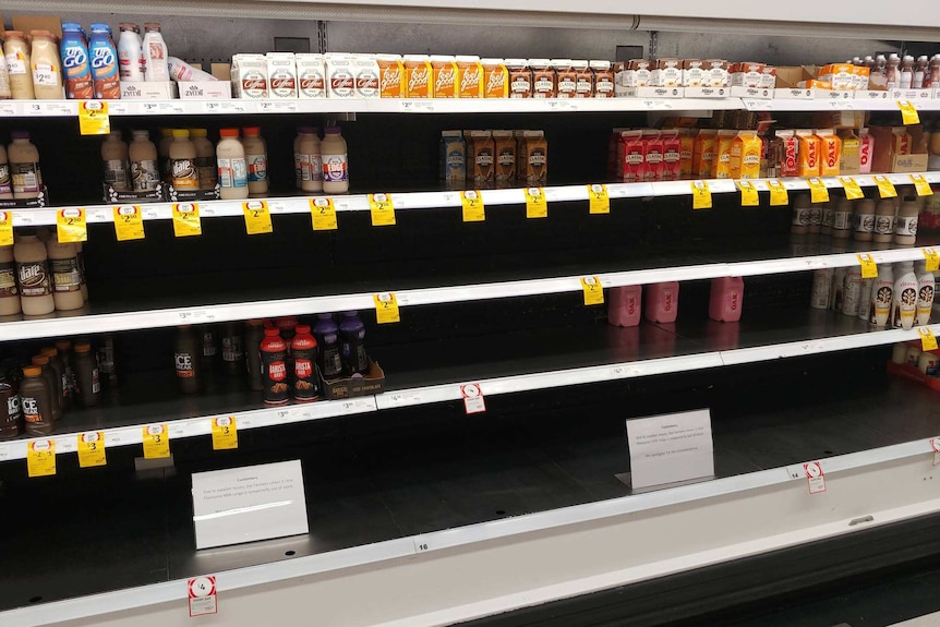 Milk shelves at a supermarket with empty rows of iced coffee