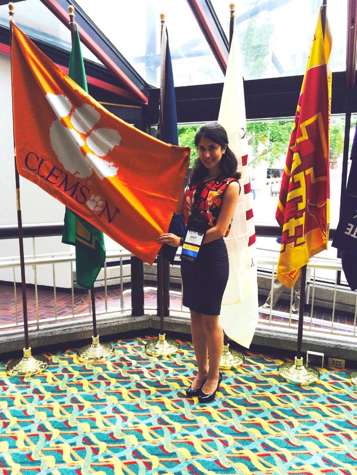 Nazanin Zinouri holds an orange Clemson University flag.