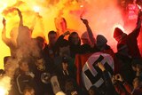 Supporters light flares and wave a Nazi flag