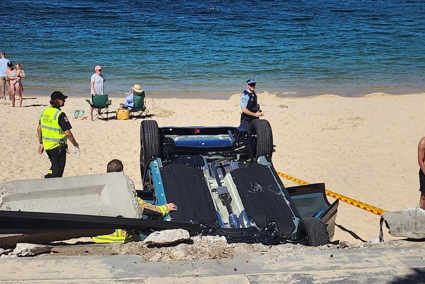 car flipped on its roof at Sydney's Balmoal Beach with police standing watch