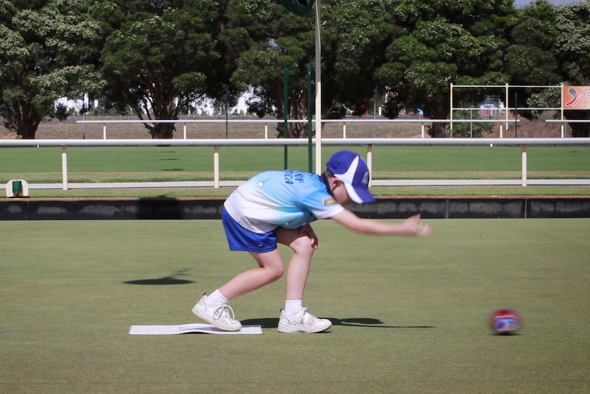 A nine-year-old boy playing bowls