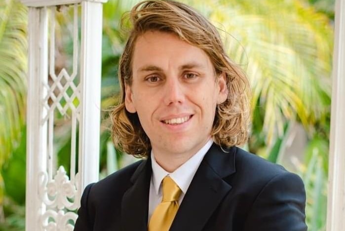 Political researcher Pierre-Christophe Pantz wearing a suit and yellow tie.