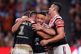 A man embraces his teammates after scoring a try