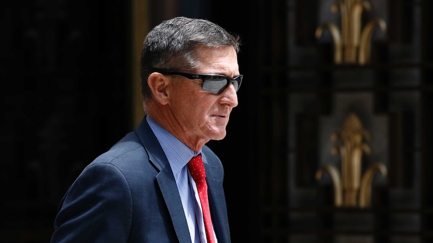 Michael Flynn departs a federal courthouse wearing sunglasses and a blue suit.