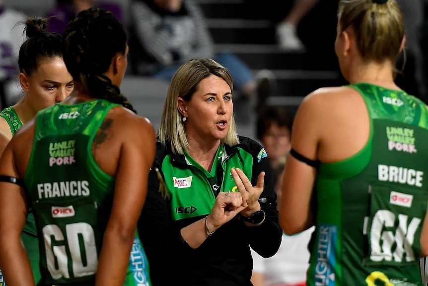 The West Coast Fever Super Netball head coach speaks to her players during a break.