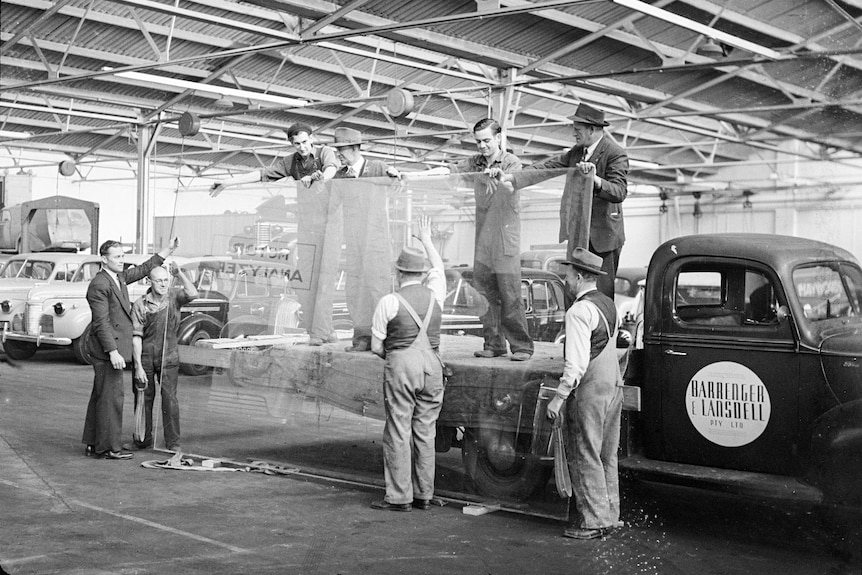 A World War Two image of men holding a large panel of glass on a truck