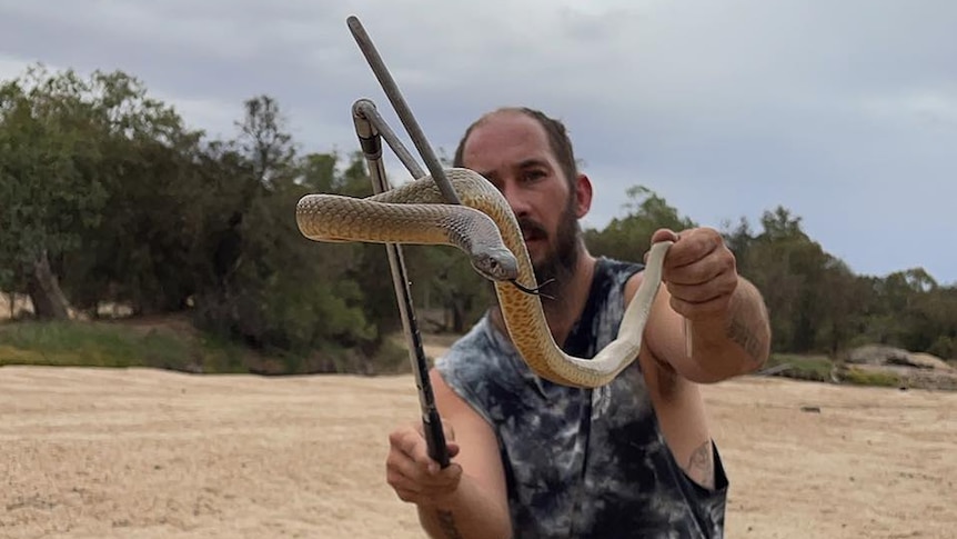 A man with a snake on a stick.
