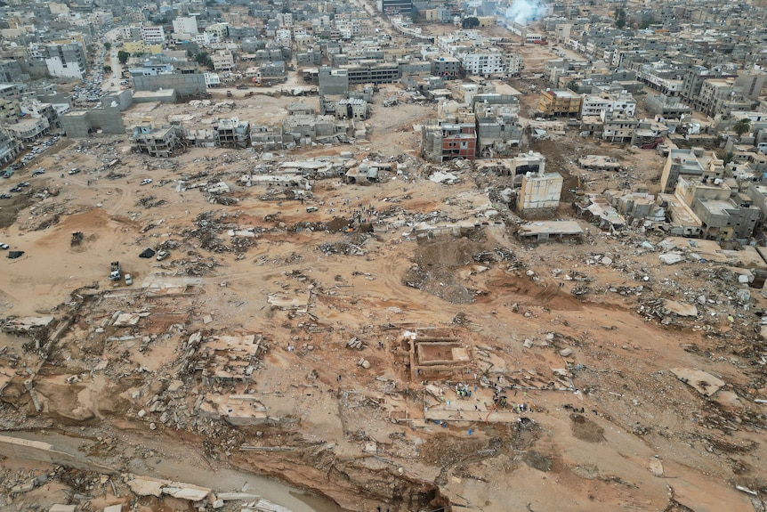An aerial view of the city of Derna, showing destroyed buildings, mud and debris