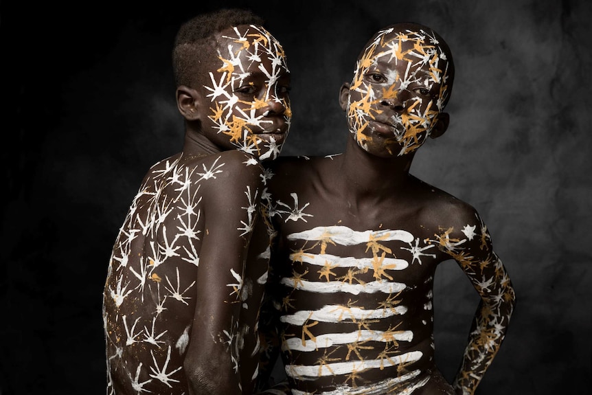 Two Ethiopian boys covered in white and yellow paint
