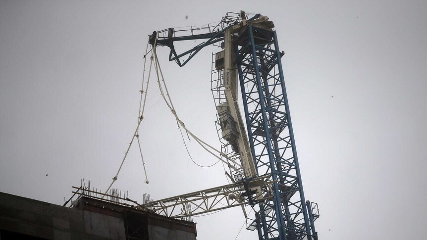A collapsed crane is seen on top of a high rise in Miami