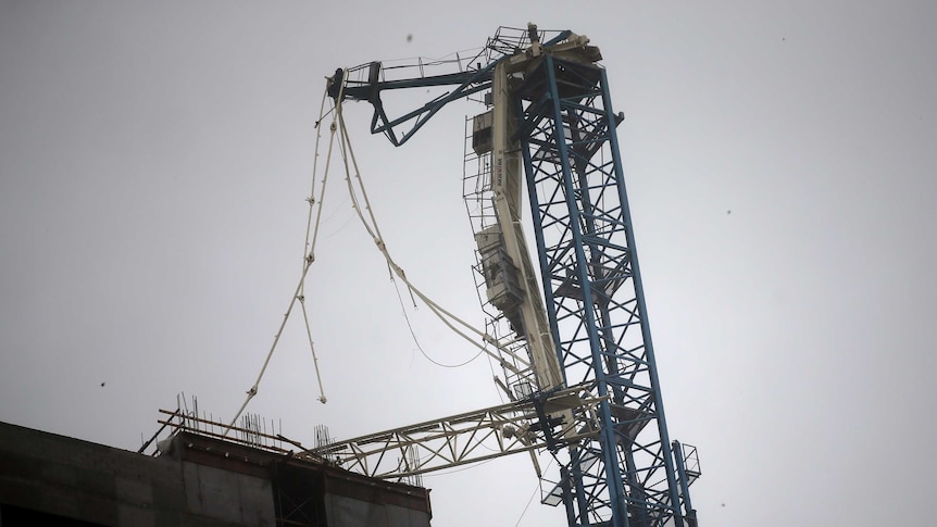 A collapsed crane is seen on top of a high rise in Miami