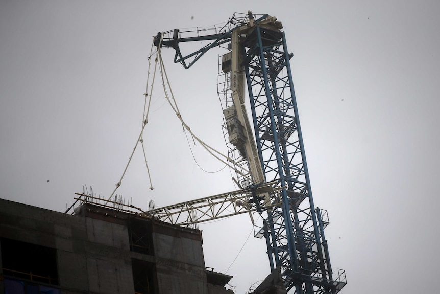 A collapsed crane is seen on top of a high rise in Miami