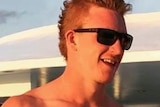 A young shirtless man wearing sunglasses.