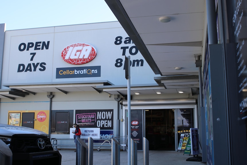 A photo from a footpath of an IGA supermarket store. The sign reads OPEN 7 DAYS and the IGA sign is red and cracking.