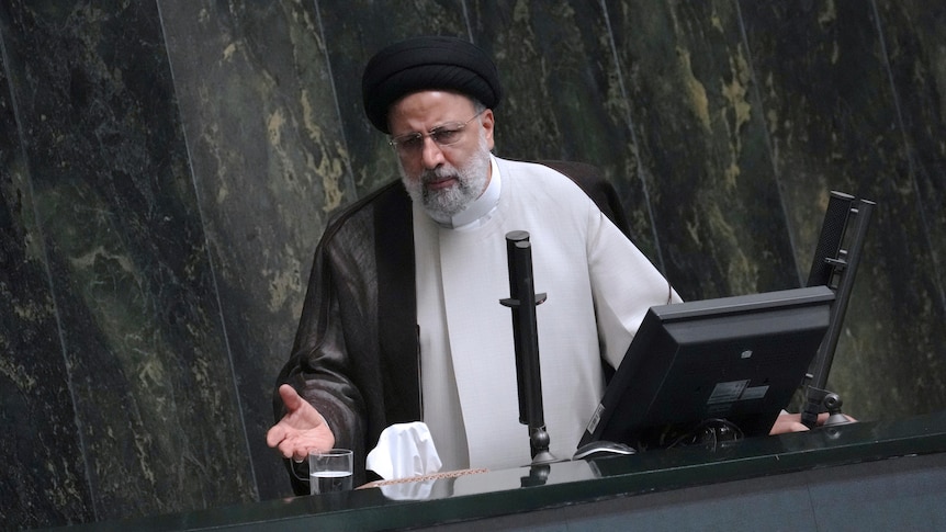 Iranian President Ebrahim Raisi in front of microphones in a speech. 