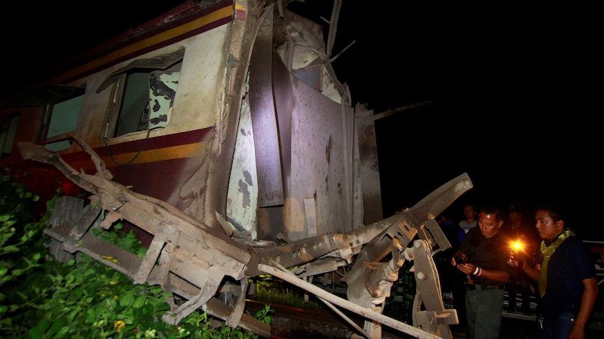 Military personnel inspect a derailed train carriage which was the site of a bomb blast in Pattani, Thailand.