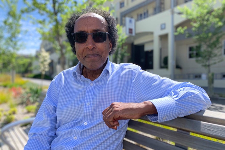 Businessman sits on park bench