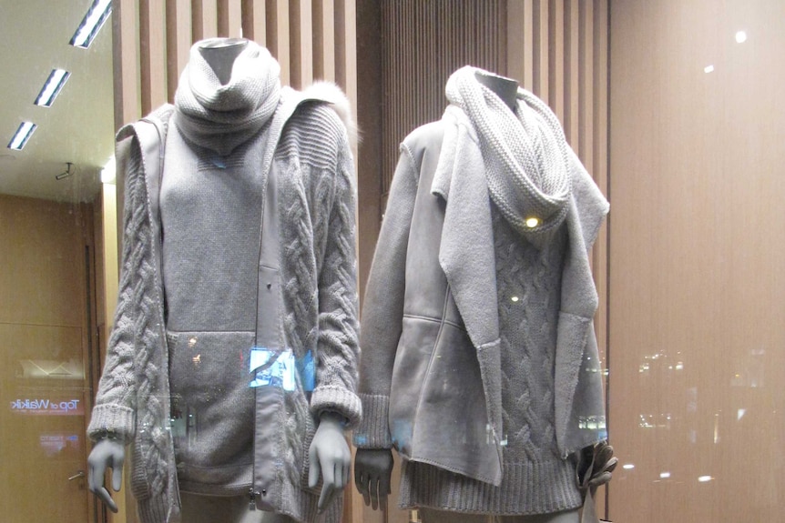 Two store models wearing woollen garments, jackets and turtle-neck sweaters