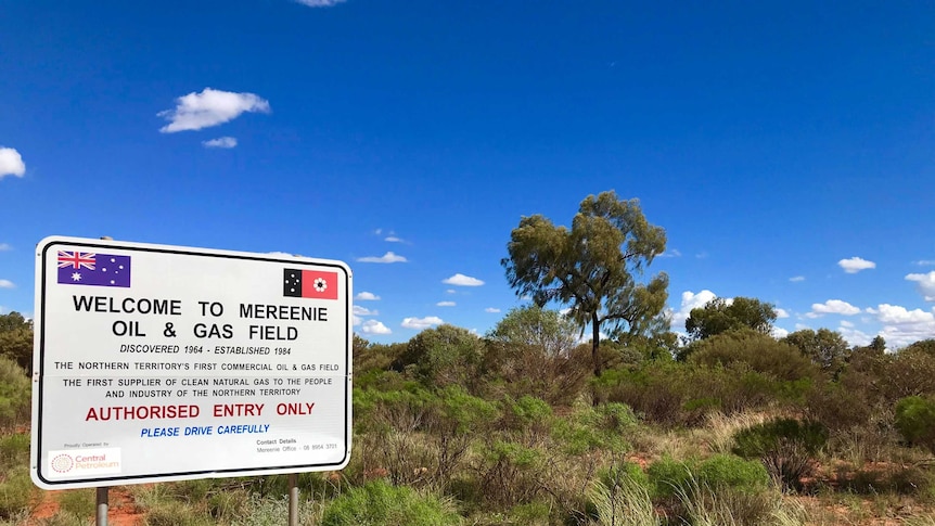 Sign for a gas field on red dirt and spinifex.