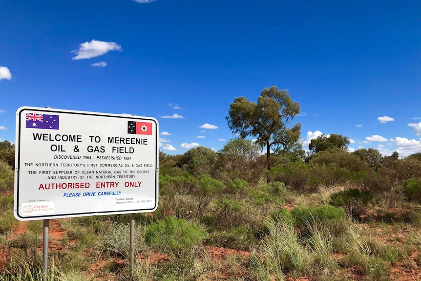 Sign for a gas field on red dirt and spinifex.