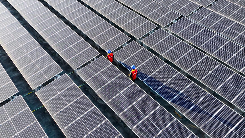 photovoltaic cells on a roof with two workers