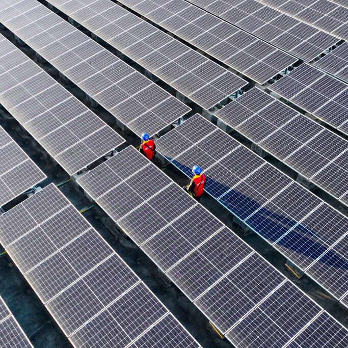 photovoltaic cells on a roof with two workers