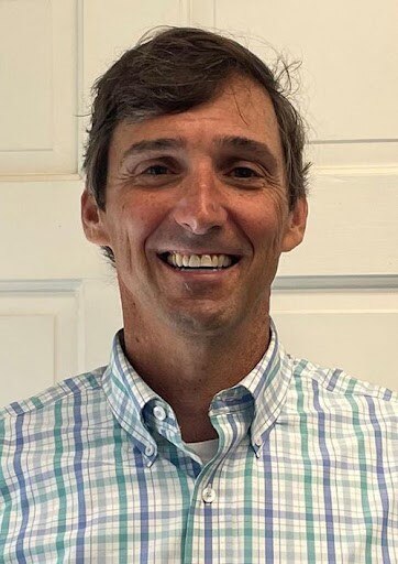 A man in his forties smiling for a photo