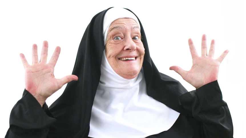 A nun in a traditional habit smiling and waving