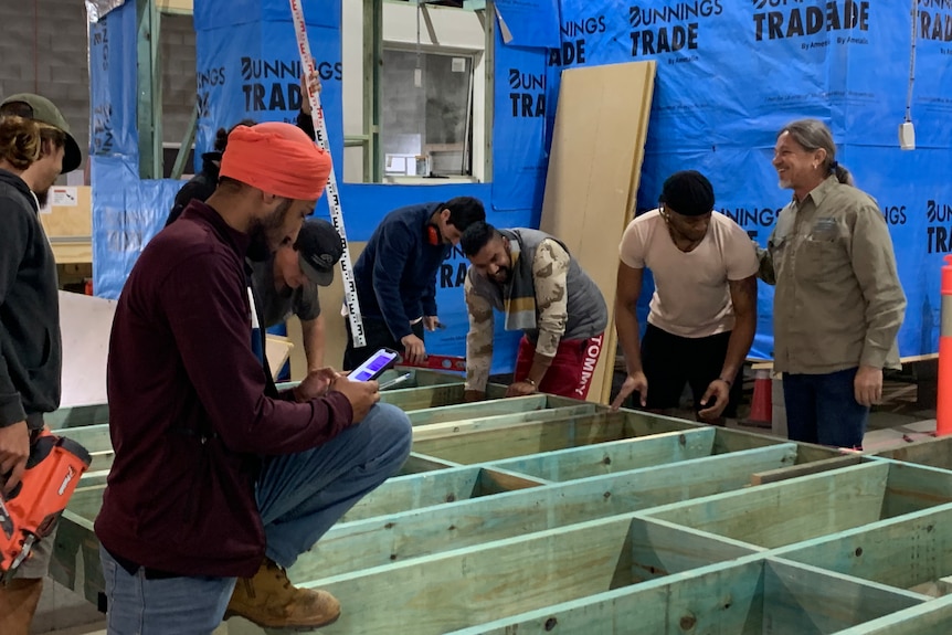 Grupo de estudiantes que trabajan en el marco de construcción de madera