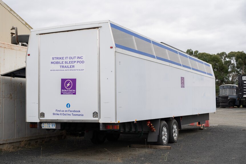 A trailer which says: "Strike it Out Inc Mobile Sleep Pod Trailer'.
