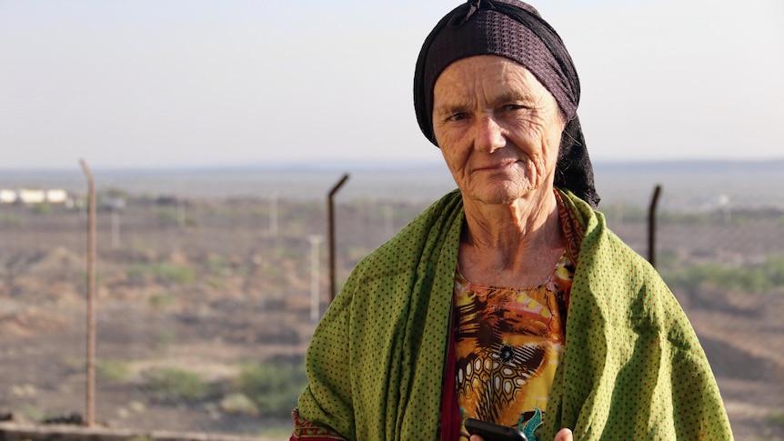 A kind-looking older woman wearing brightly coloured flowing clothes commonly worn by Afar people in Ethiopia