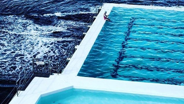 A swimmer sits on the edge of one of the pools at the Bondi Icebergs Club.