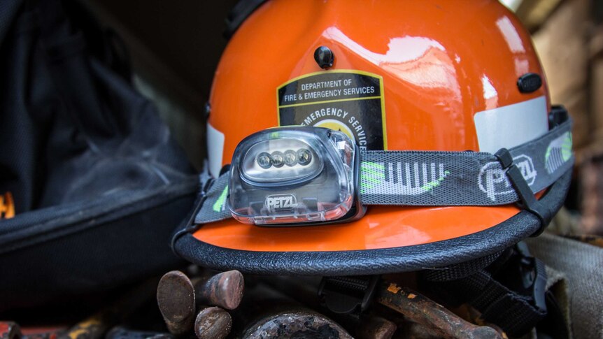 An SES hard hat rests on some tools.