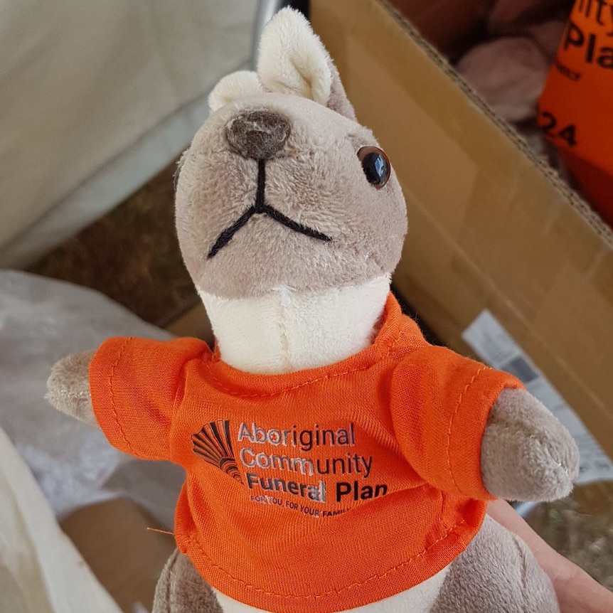 A kangaroo soft toy wearing an orange t-shirt advertising funeral insurance