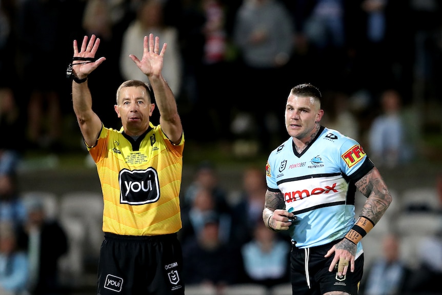 Josh Dugan runs next to referee Ben Cummins, who is holding both hands up above his head with his fingers outstretched