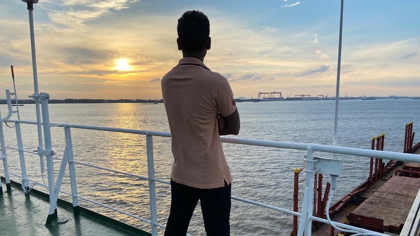 A seafarer, who does not want to be identified, looks towards a port in the distance.