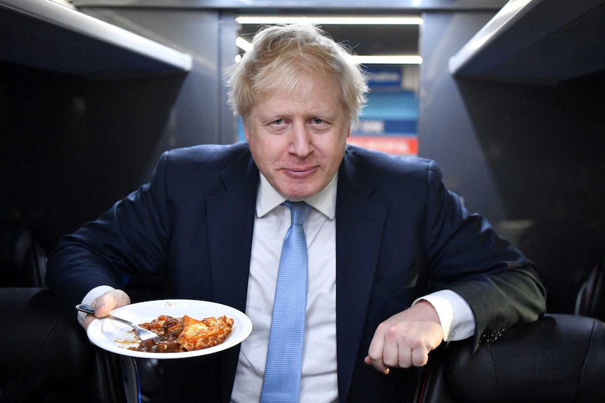 Boris Johnson holding a slice of beef pie on a plate
