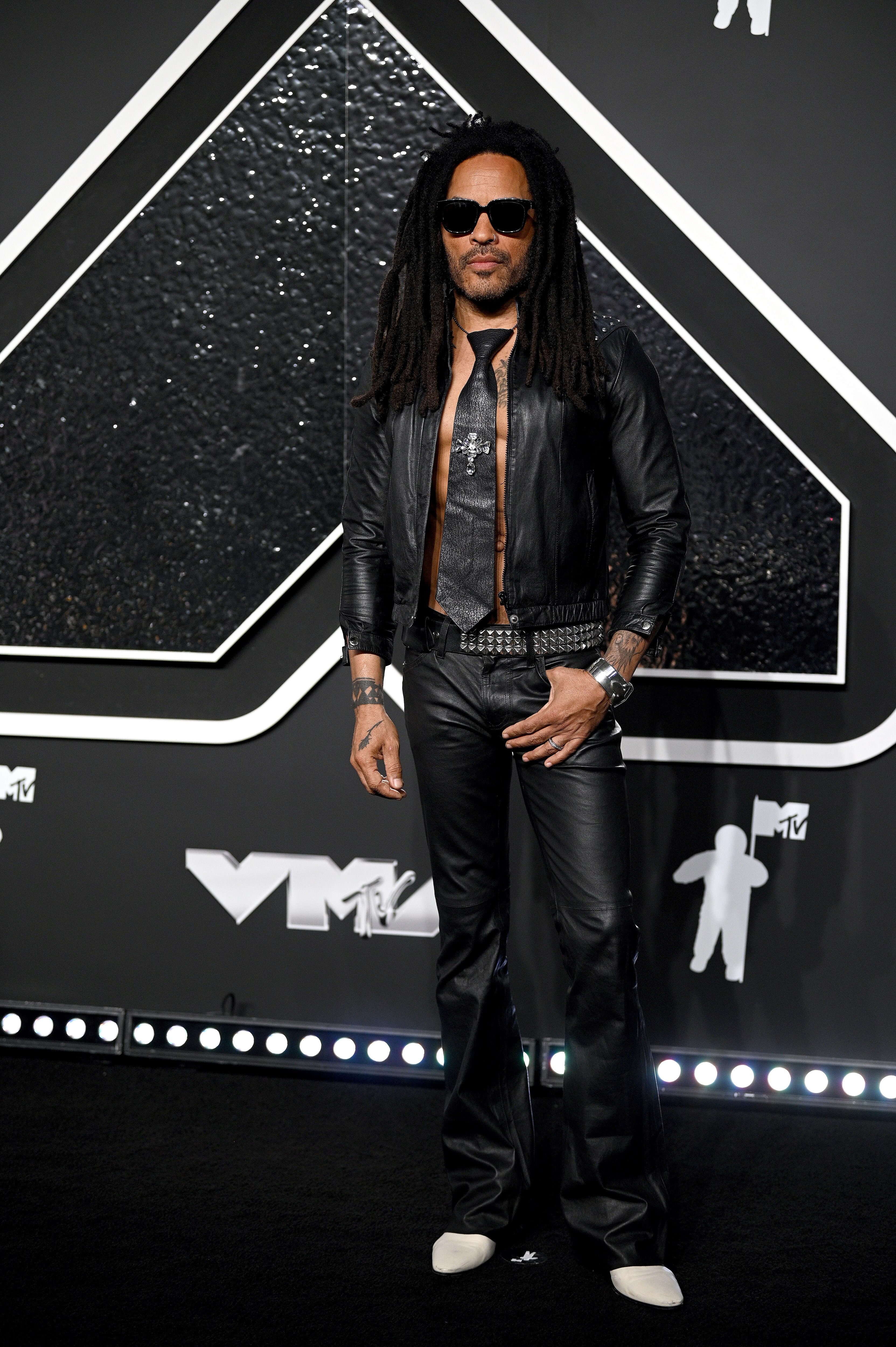 Lenny Kravitz wearing all back on the VMAs red carpet. He has no shirt on but a tie