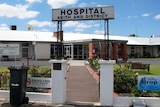 An arched sign reading 'Hospital Keith and District' outside a brick hospital building.