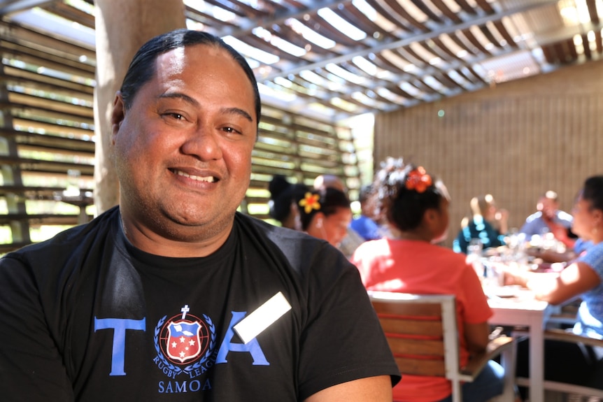 samoan man smiling at the camera, wearing black t-shirt with nametag 'Bill'