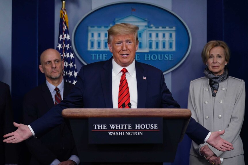 President Donald Trump speaks during press briefing with the coronavirus task force standing behind him.