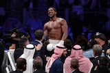 A boxer laughs in the ring after his win in a world heavyweight title fight.